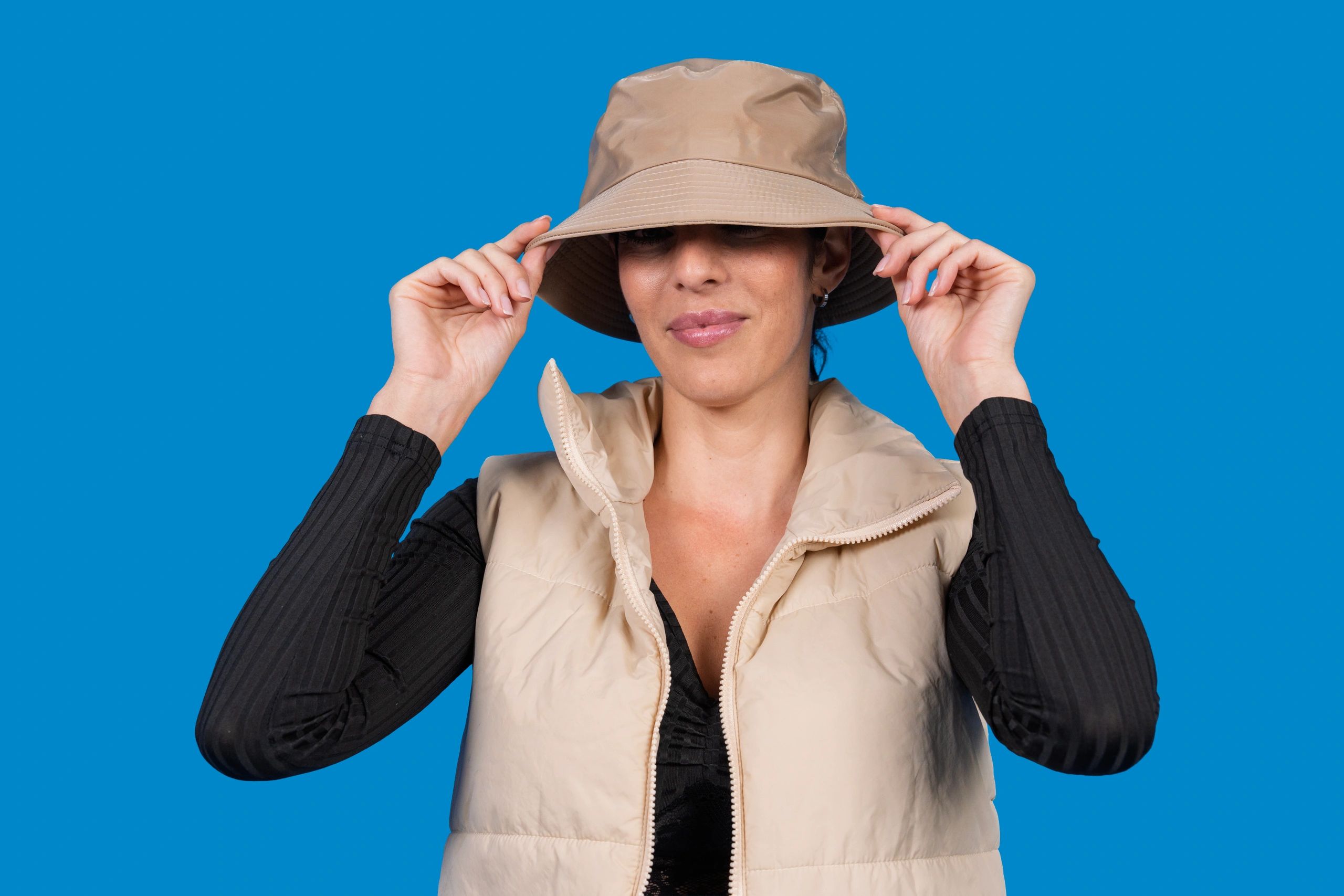 Woman adjusting a bucket hat in a studio portrait