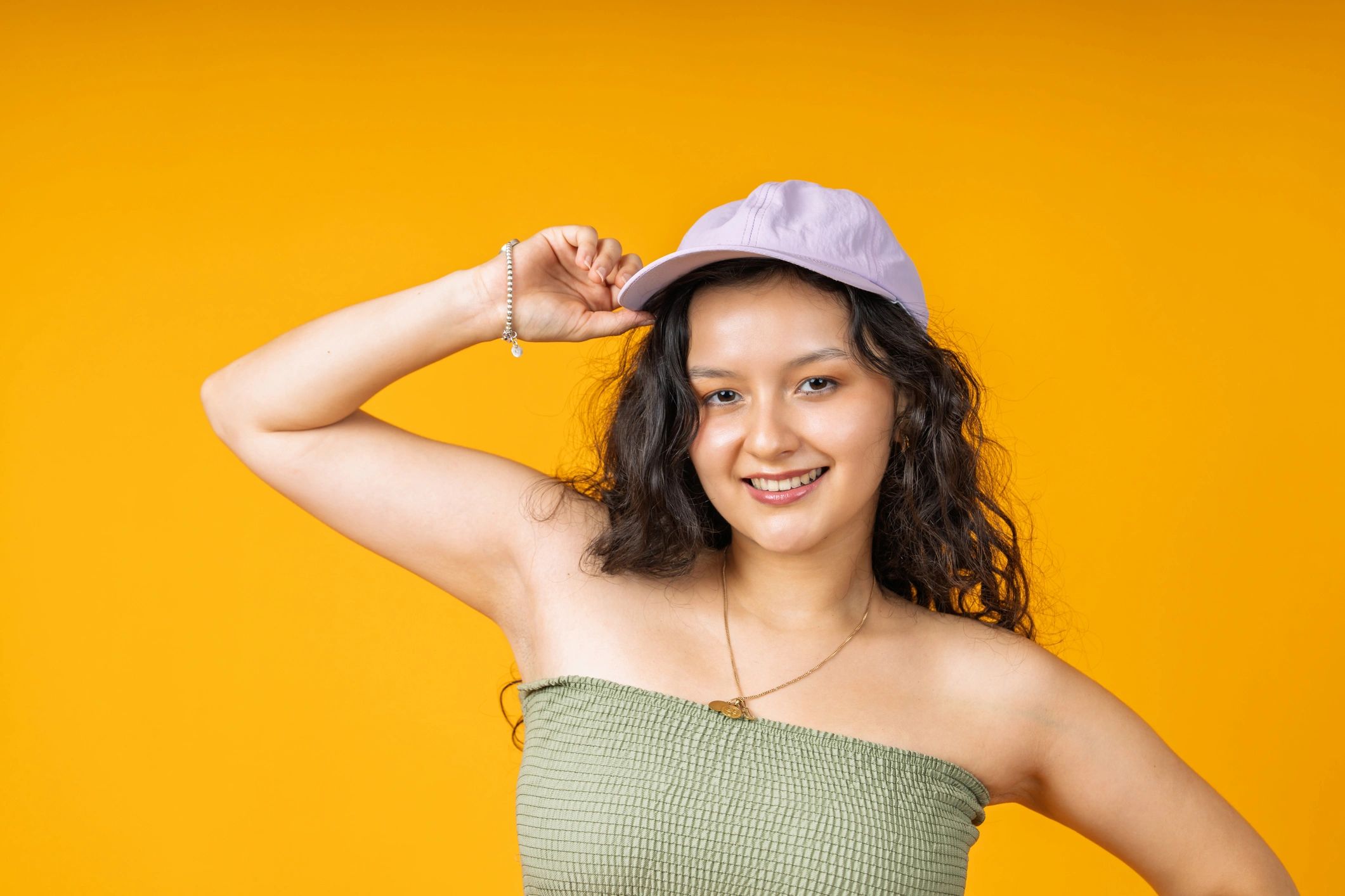 Smiling woman wearing a baseball cap in a studio